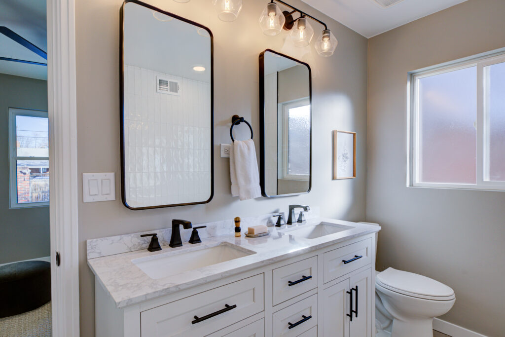 master bath with his and her vanity and mirrors with black rounded edges